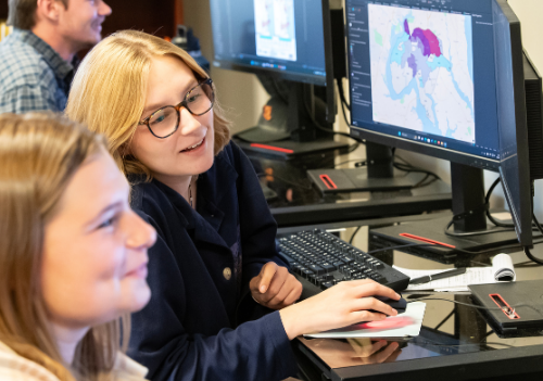 smiling on campus employer.  dark hair. 